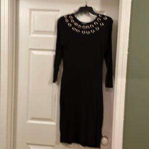 Sexy, black dress accentuated with gold hoops.